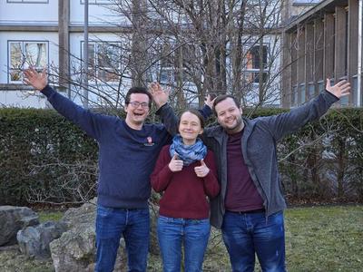 Max Stange (links), Mareen Hoppe (Mitte) und Erik Bachmann (rechts) symbolisieren mit ihren Armen jeweils transversale T- , longitudinale L- und noch einmal transversale T-Polarisation.